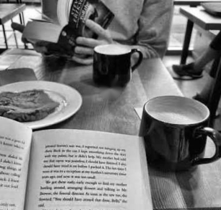 Libros y café en una mesa compartida